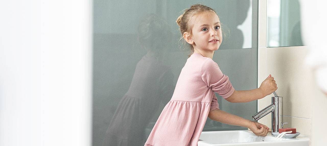 Κορίτσι πλένει χέρια με mini ταχυθερμαντήρα STIEBEL ELTRON EIL σε WC επισκεπτών